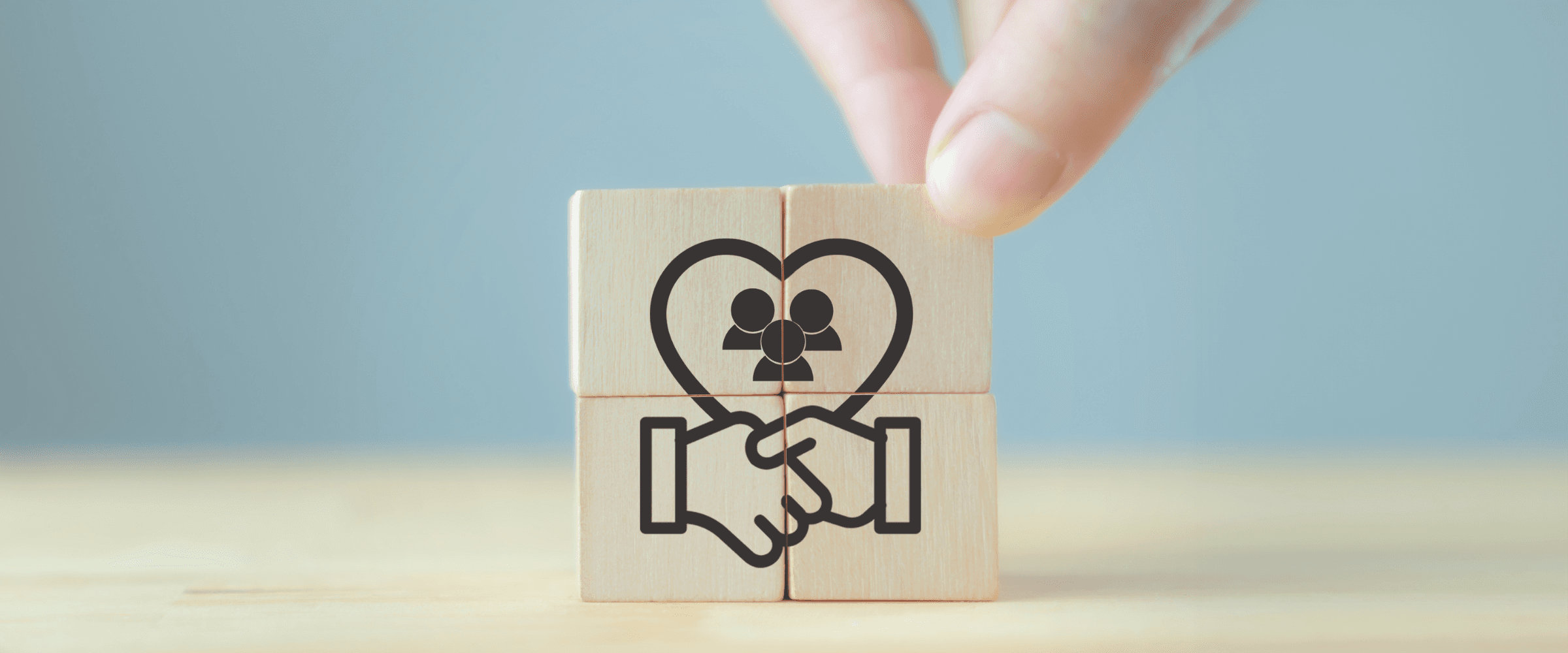 Four wooden blocks creating a handshake.